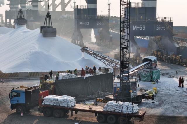 Urea fertiliser is loaded onto a cargo ship for export at a port in Yantai, in China’s eastern Shandong province on March 26, 2026. (Photo by CN-STR / AFP) / China OUT