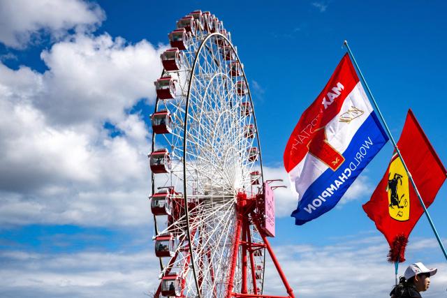 Fans carry the flags of their supporting teams ahead of the Formula One Japanese Grand Prix in Suzuka on March 26, 2026. (Photo by Philip FONG / AFP)