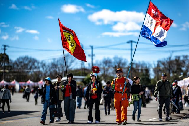 Fans carry the flags of their supporting teams ahead of the Formula One Japanese Grand Prix in Suzuka on March 26, 2026. (Photo by Philip FONG / AFP)