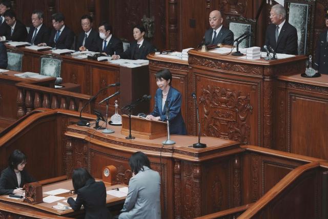 Japan's Prime Minister Sanae Takaichi (C) answers questions from an opposition lawmaker regarding her report on the results of her recent visit to the United States during a plenary session of the House of Representatives at Parliament in Tokyo on March 26, 2026. (Photo by Kazuhiro NOGI / AFP)
