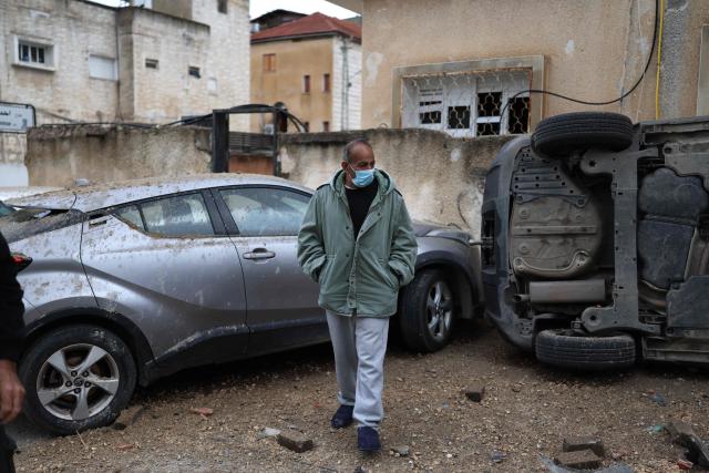 A man surveys the damage at the site struck by a projectile in the Arab-Israeli city of Kfar Qassem on March 26, 2026. The Israeli military said air defences responded to missile attacks from Iran on March 26, that according to medics left six people lightly wounded and caused some damage. The Middle East was sparked by joint US-Israeli strikes on Iran that triggered a wave of retaliatory missile and drone attacks against Israel and several other countries in the region. (Photo by Ilia YEFIMOVICH / AFP) / 