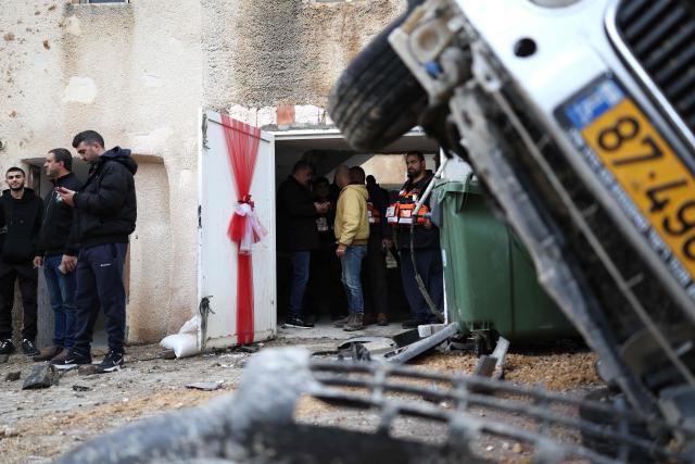 Israeli Security personnel and residents survey the site struck by a projectile in the Arab-Israeli city of Kfar Qassem on March 26, 2026. The Israeli military said air defences responded to missile attacks from Iran on March 26, that according to medics left six people lightly wounded and caused some damage. The Middle East was sparked by joint US-Israeli strikes on Iran that triggered a wave of retaliatory missile and drone attacks against Israel and several other countries in the region. (Photo by Ilia YEFIMOVICH / AFP) / 