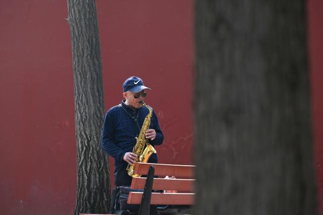 A man plays the axophone outside of the Jingshan park in Beijing on March 26, 2026. (Photo by ADEK BERRY / AFP)