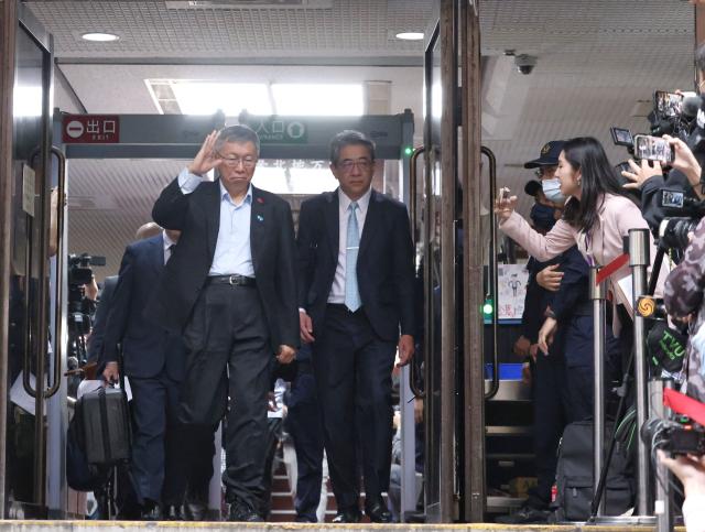 Taiwan’s former Taipei mayor and 2024 presidential candidate Ko Wen-je waves to the crowds outside of the Taipei District Court in Taipei on March 26, 2026. Ko, who once ran for the presidency, was sentenced on March 26, to 17 years in prison for taking bribes and misusing political donations. (Photo by I-Hwa Cheng / AFP)