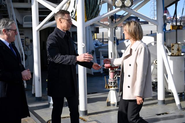 British Prime Minister Keir Starmer (L) looks on as Finnish President Alexander Stubb (C) welcomes Icelandic Prime Minister Kristrun Frostadottir (R) onboard the Finnish Border Guard offshore patrol vessel Turva prior the Joint Expeditionary Force JEF Leaders’ Summit in Helsinki, Finland on March 26, 2026. The topics on the agenda include support from the JEF countries to Ukraine and the overall security situation in Europe. (Photo by Heikki Saukkomaa / Lehtikuva / AFP) / Finland OUT