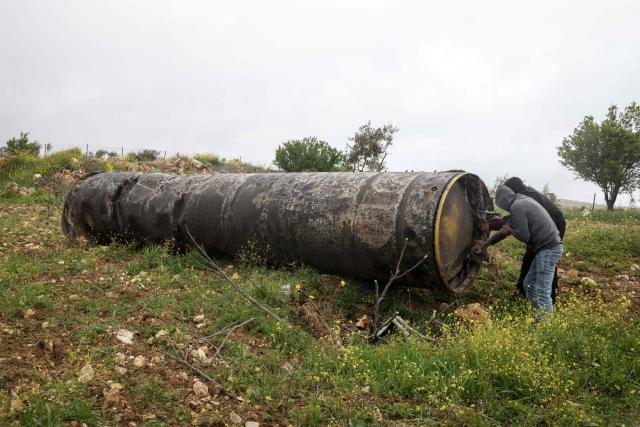 Palestinian residents inspect the remnants of an missile that landed in the Israeli-occupied West Bank village of Beitin, northeast of the city of Ramallah on March 26, 2026. On February 28, Israel and the United States launched strikes on Iran killing its supreme leader and triggering a war that spread across the Middle East and unleashed chaos across global markets. (Photo by Zain JAAFAR / AFP) / 
