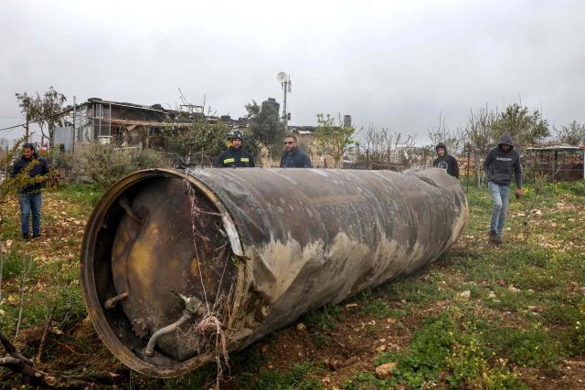 Palestinian residents inspect the remnants of an missile that landed in the Israeli-occupied West Bank village of Beitin, northeast of the city of Ramallah on March 26, 2026. On February 28, Israel and the United States launched strikes on Iran killing its supreme leader and triggering a war that spread across the Middle East and unleashed chaos across global markets. (Photo by Zain JAAFAR / AFP) / 