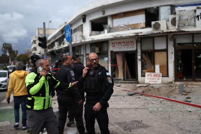 Israeli security forces cordon off the area following a projectile strike on south Tel Aviv on March 26, 2026. The Middle East was sparked by joint US-Israeli strikes on Iran that triggered a wave of retaliatory missile and drone attacks against Israel and several other countries in the region. (Photo by Ilia YEFIMOVICH / AFP) / 
