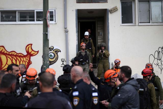 Israeli security forces and first responders arrive at the scene following a projectile strike in south Tel Aviv on March 26, 2026. The Middle East was sparked by joint US-Israeli strikes on Iran that triggered a wave of retaliatory missile and drone attacks against Israel and several other countries in the region. (Photo by Ilia YEFIMOVICH / AFP) / 