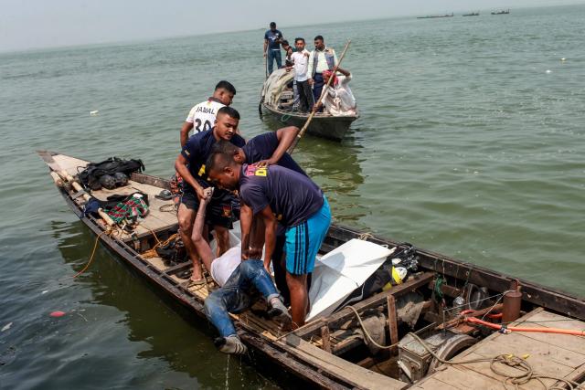 EDITORS NOTE: Graphic content / Navy divers recover the body of a victim following an accident involving a bus that plunged into the Padma River in Goalanda in Bangladesh’s Rajbari district on March 26, 2026. Rescue teams, including navy divers in Bangladesh, have recovered 24 bodies from a bus that plunged into a river at a ferry crossing, officials said on March 26, 2026. The bus sank into the deep waters of the Padma River in Goalanda on Wednesday, about 65 kilometres (40 miles) west of the capital, Dhaka. (Photo by AFP)