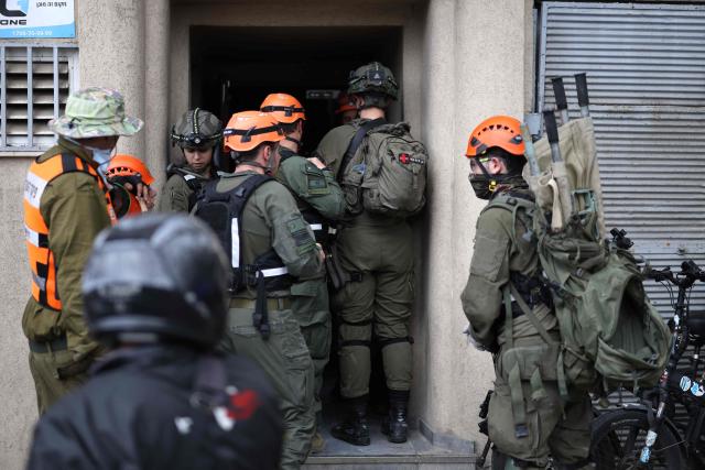 Israeli security forces and first responders arrive at the scene following a projectile strike in south Tel Aviv on March 26, 2026. The Middle East was sparked by joint US-Israeli strikes on Iran that triggered a wave of retaliatory missile and drone attacks against Israel and several other countries in the region. (Photo by Ilia YEFIMOVICH / AFP) / 