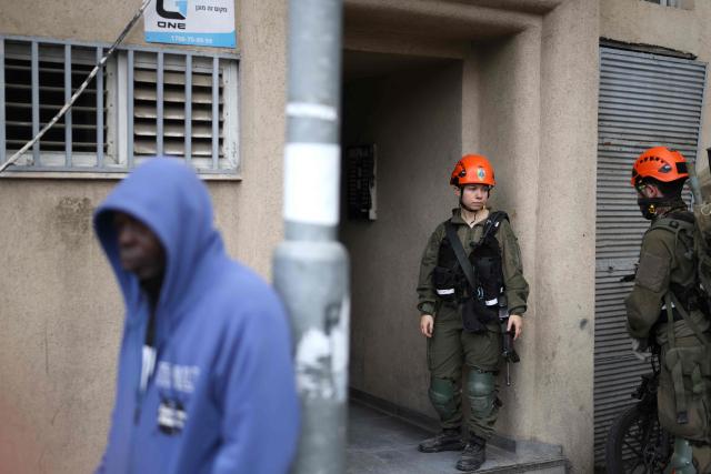 Israeli security forces and first responders arrive at the scene following a projectile strike in south Tel Aviv on March 26, 2026. The Middle East was sparked by joint US-Israeli strikes on Iran that triggered a wave of retaliatory missile and drone attacks against Israel and several other countries in the region. (Photo by Ilia YEFIMOVICH / AFP) / 