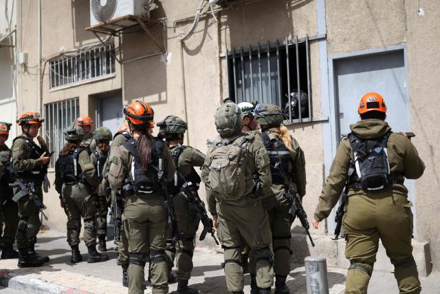 Israeli security forces and first responders arrive at the scene following a projectile strike in south Tel Aviv on March 26, 2026. The Middle East was sparked by joint US-Israeli strikes on Iran that triggered a wave of retaliatory missile and drone attacks against Israel and several other countries in the region. (Photo by Ilia YEFIMOVICH / AFP) / 