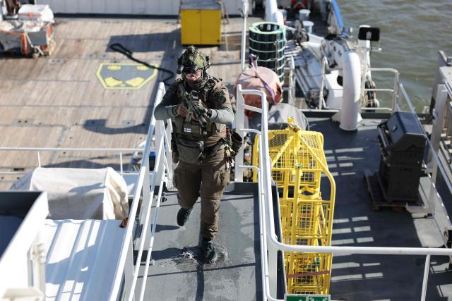 A member of the Finnish Border Guard takes part in an exercise, during the JEF leaders' visit on the Finnish Border Guard offshore patrol vessel Turva, prior the Joint Expeditionary Force JEF Leaders’ Summit in Helsinki, Finland on March 26, 2026. The topics on the agenda include support from the JEF countries to Ukraine and the overall security situation in Europe. (Photo by Adrian DENNIS / POOL / AFP)