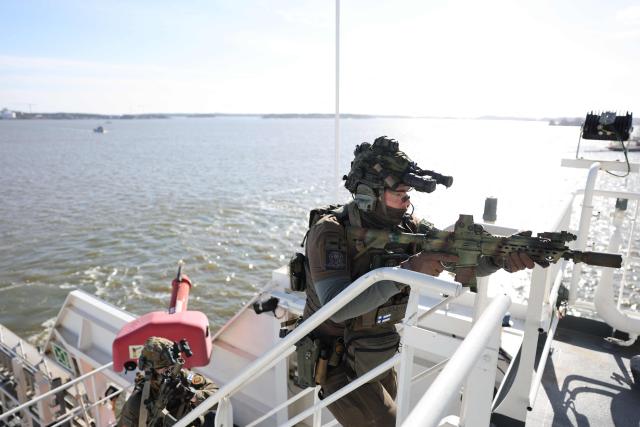 A member of the Finnish Border Guard takes part in an exercise, during the JEF leaders' visit on the Finnish Border Guard offshore patrol vessel Turva, prior the Joint Expeditionary Force JEF Leaders’ Summit in Helsinki, Finland on March 26, 2026. The topics on the agenda include support from the JEF countries to Ukraine and the overall security situation in Europe. (Photo by Adrian DENNIS / POOL / AFP)