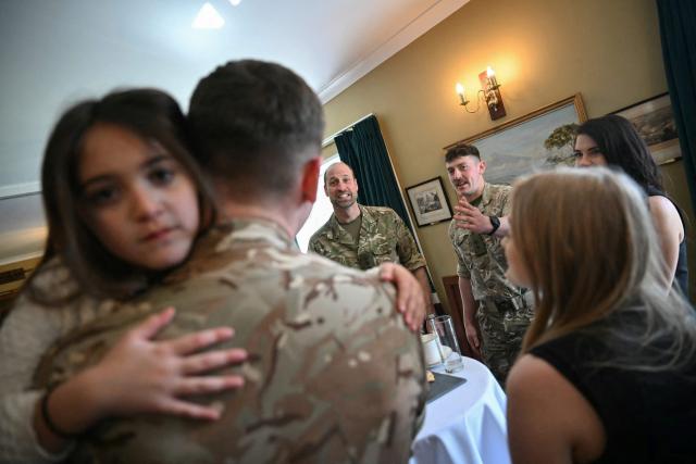 Britain's Prince William (behind C), Prince of Wales as Colonel-in-Chief of the Regiment, meets with soldiers of the 1st Battalion Mercian Regiment and family members following their six-month deployment to Estonia, in Bulford in south-west England on March 26, 2026. (Photo by JUSTIN TALLIS / POOL / AFP)