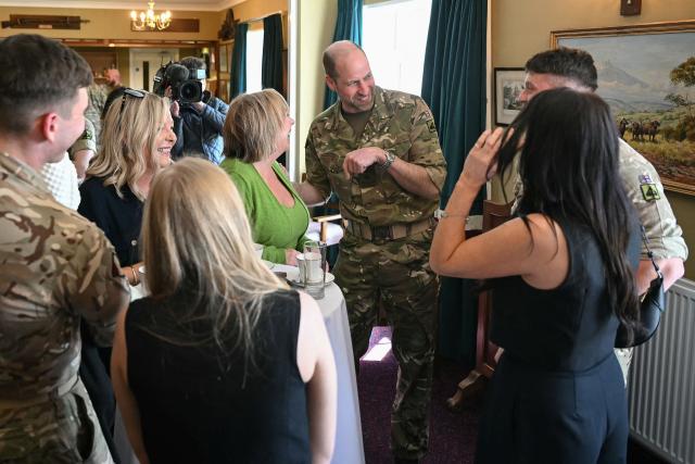 Britain's Prince William (C), Prince of Wales as Colonel-in-Chief of the Regiment, listens to a joke as he meets with soldiers of the 1st Battalion Mercian Regiment and family members following their six-month deployment to Estonia, in Bulford in south-west England on March 26, 2026. (Photo by JUSTIN TALLIS / POOL / AFP)