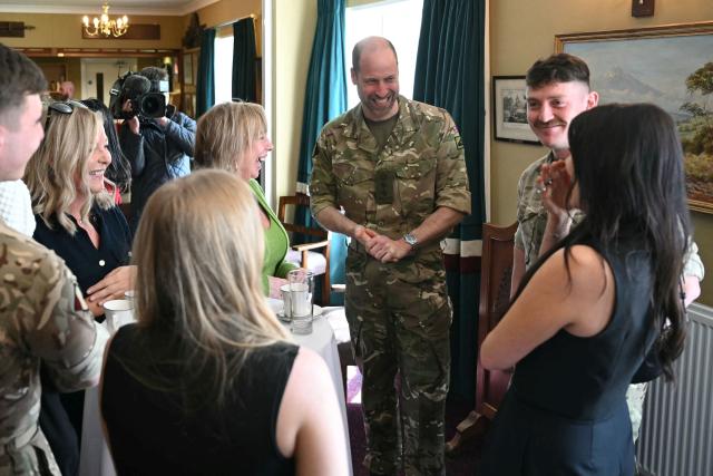 Britain's Prince William (C), Prince of Wales as Colonel-in-Chief of the Regiment, listens to a joke as he meets with soldiers of the 1st Battalion Mercian Regiment and family members following their six-month deployment to Estonia, in Bulford in south-west England on March 26, 2026. (Photo by JUSTIN TALLIS / POOL / AFP)