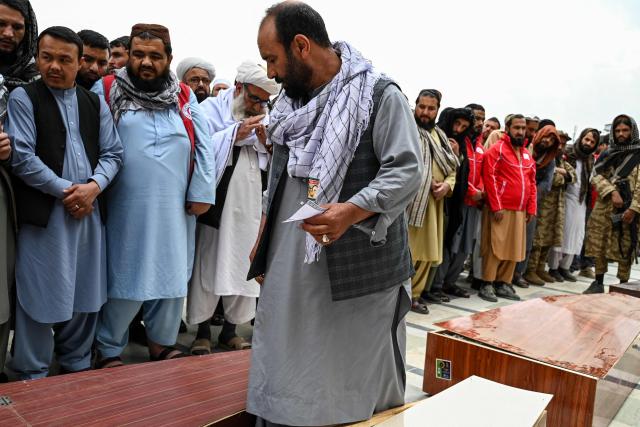 Afghan man Abdul Hai Hamidi (C) looks at a coffin as he searches for his relative during the second mass funeral for victims killed by a Pakistani airstrike that struck a drug rehabilitation centre, at the Eid Gah Mosque in Kabul on March 26, 2026. (Photo by Wakil Kohsar / AFP)