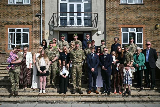 Britain's Prince William (C), Prince of Wales as Colonel-in-Chief of the Regiment, poses with soldiers of the 1st Battalion Mercian Regiment and family members following their six-month deployment to Estonia, in Bulford in south-west England on March 26, 2026. (Photo by JUSTIN TALLIS / POOL / AFP)