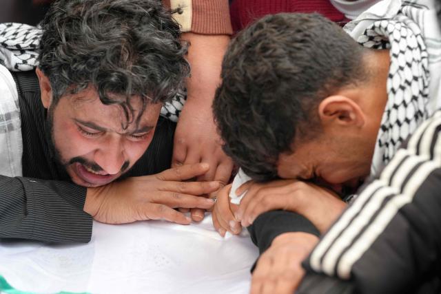 Family members and friends mourn over the body of Ahmed Al-Jubouri, a member of Iraq’s Ministry of Defense who was killed at the Habbaniyah military base following an aerial attack, during his funeral at the Imam Ali Shrine in the southern city of Najaf on March 26, 2026. Iraq announced on March 25 that it will file a complaint with the UN Security Council regarding the attacks targeting its territory since the start of the war, hours after seven soldiers were killed in an attack on their position in the west of the country. (Photo by Qassem al-KAABI / AFP)