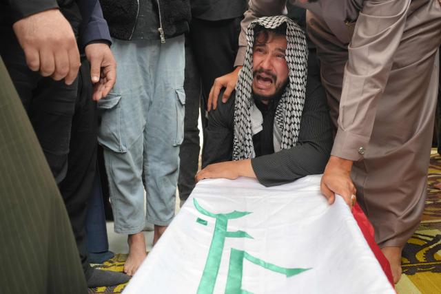 A family member mourns over the coffin of Ahmed Al-Jubouri, a member of Iraq’s Ministry of Defense who was killed at the Habbaniyah military base following an aerial attack, during his funeral at the Imam Ali Shrine in the southern city of Najaf on March 26, 2026. Iraq announced on March 25 that it will file a complaint with the UN Security Council regarding the attacks targeting its territory since the start of the war, hours after seven soldiers were killed in an attack on their position in the west of the country. (Photo by Qassem al-KAABI / AFP)