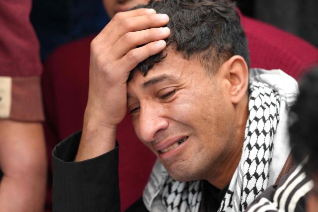 A family member mourns over the coffin of Ahmed Al-Jubouri, a member of Iraq’s Ministry of Defense who was killed at the Habbaniyah military base following an aerial attack, during his funeral at the Imam Ali Shrine in the southern city of Najaf on March 26, 2026. Iraq announced on March 25 that it will file a complaint with the UN Security Council regarding the attacks targeting its territory since the start of the war, hours after seven soldiers were killed in an attack on their position in the west of the country. (Photo by Qassem al-KAABI / AFP)