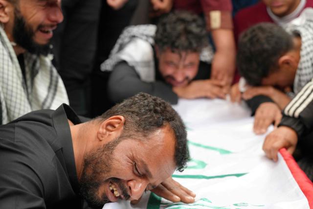 Family members and friends mourn over the body of Ahmed Al-Jubouri, a member of Iraq’s Ministry of Defense who was killed at the Habbaniyah military base following an aerial attack, during his funeral at the Imam Ali Shrine in the southern city of Najaf on March 26, 2026. Iraq announced on March 25 that it will file a complaint with the UN Security Council regarding the attacks targeting its territory since the start of the war, hours after seven soldiers were killed in an attack on their position in the west of the country. (Photo by Qassem al-KAABI / AFP)