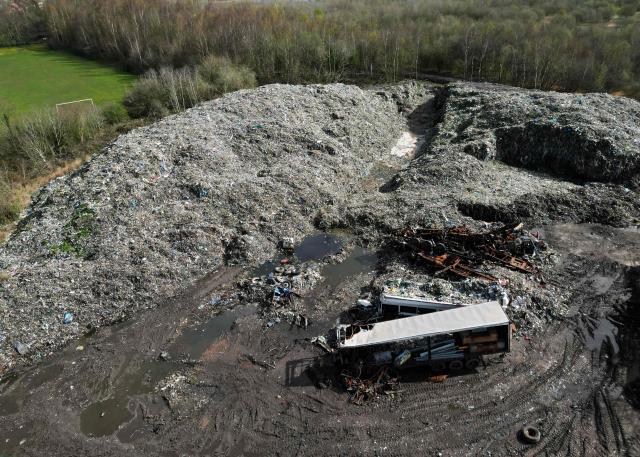 This aerial view shows an illegal rubbish dump, estimated to contain 25,000 tonnes of waste and which is due to be cleared by the Environment Agency, in Bickershaw, near Wigan in north-west England on March 26, 2026. Waste has been deposited on the site, which is partly owned by several parties, including Wigan Council and the Duchy of Lancaster, since October 2024. (Photo by Oli SCARFF / AFP)