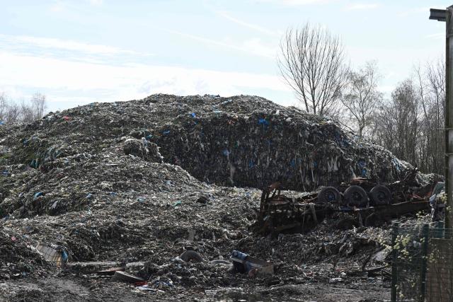 An illegal rubbish dump, estimated to contain 25,000 tonnes of waste and which is due to be cleared by the Environment Agency, is pictured in Bickershaw, near Wigan in north-west England on March 26, 2026. Waste has been deposited on the site, which is partly owned by several parties, including Wigan Council and the Duchy of Lancaster, since October 2024. (Photo by Oli SCARFF / AFP)
