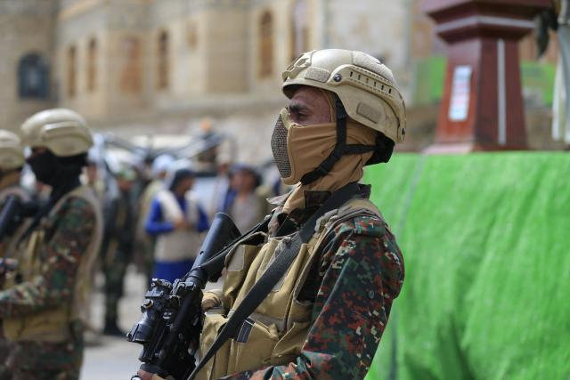Yemeni soldiers stand guard while supporters of Yemen's Huthi movement attend an event commemorating the ninth anniversary of the Saudi-led intervention in their country, in the capital Sanaa on March 26, 2026. (Photo by Mohammed HUWAIS / AFP)