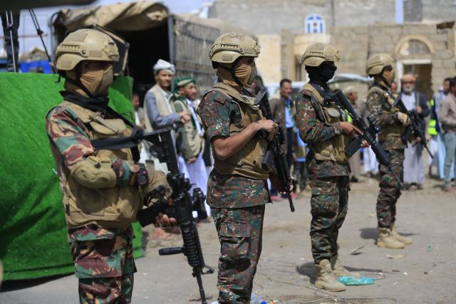 Yemeni soldiers stand guard while supporters of Yemen's Huthi movement attend an event commemorating the ninth anniversary of the Saudi-led intervention in their country, in the capital Sanaa on March 26, 2026. (Photo by Mohammed HUWAIS / AFP)