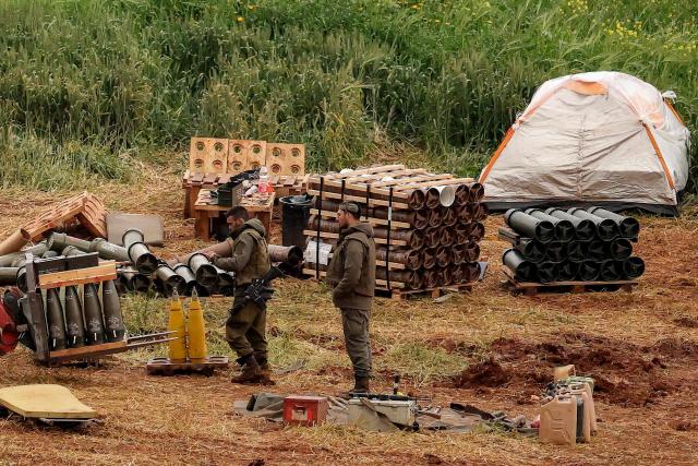 Israeli army soldiers stand by artillery shell stocks at a position in the upper Galilee in northern Israel near the border with southern Lebanon on March 26, 2026. Lebanon was drawn into the Middle East war on March 2, when pro-Iran Hezbollah launched rockets towards Israel in response to US-Israeli strikes that killed Iranian supreme leader on February 28. (Photo by Jack GUEZ / AFP) / 