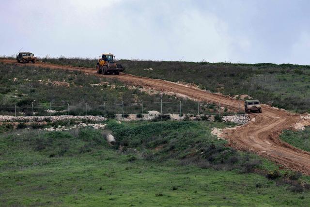 Israeli military vehicles move along a road in southern Lebanon close to the Israeli border on March 26, 2026. Lebanon was drawn into the Middle East war on March 2, when pro-Iran Hezbollah launched rockets towards Israel in response to US-Israeli strikes that killed Iranian supreme leader on February 28. (Photo by Jack GUEZ / AFP) / 