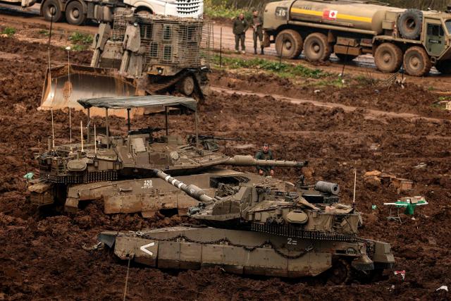 Israeli army Merkava main battle tanks are positioned in the upper Galilee in northern Israel near the border with southern Lebanon on March 26, 2026. Lebanon was drawn into the Middle East war on March 2, when pro-Iran Hezbollah launched rockets towards Israel in response to US-Israeli strikes that killed Iranian supreme leader on February 28. (Photo by Jack GUEZ / AFP) / 