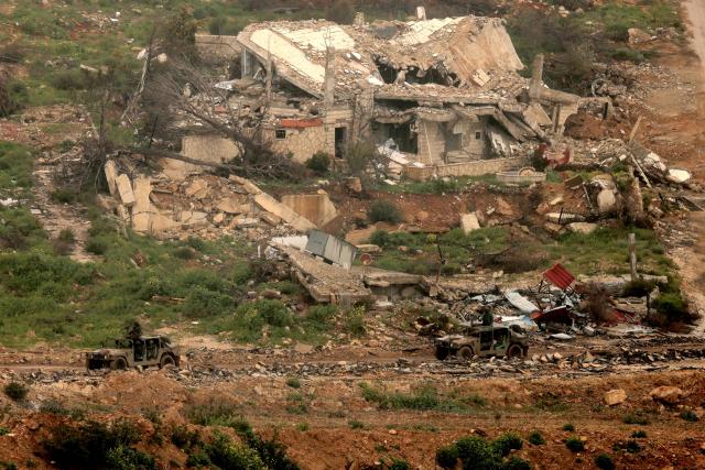 Israeli military vehicles move past destroyed buildings in southern Lebanon close to the Israeli border on March 26, 2026. Lebanon was drawn into the Middle East war on March 2, when pro-Iran Hezbollah launched rockets towards Israel in response to US-Israeli strikes that killed Iranian supreme leader on February 28. (Photo by Jack GUEZ / AFP) / 