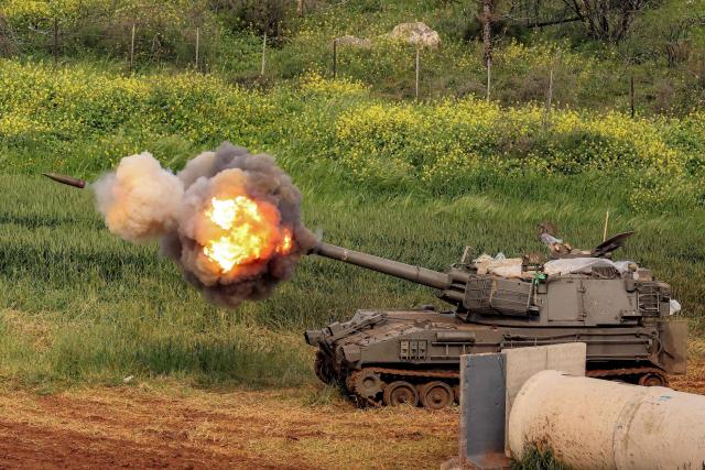 TOPSHOT - An Israeli self-propelled howitzer artillery gun fires rounds towards southern Lebanon from a position in the upper Galilee in northern Israel near the border on March 26, 2026. Lebanon was drawn into the Middle East war on March 2, when pro-Iran Hezbollah launched rockets towards Israel in response to US-Israeli strikes that killed Iranian supreme leader on February 28. (Photo by Jack GUEZ / AFP) / 