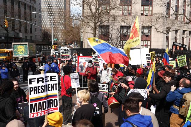 Supporters of ousted Venezuelan president Nicolas Maduro protest outside the Daniel Patrick Moynihan United States Courthouse in New York City on March 26, 2026. Lawyers for the ousted Venezuelan president Nicolas Maduro are expected to push for the dismissal of his drug trafficking charges when he appears in a New York court March 26. The Manhattan hearing comes as Washington cautiously warms ties with Caracas, with the question of who will pay the legal fees of the former autocrat and his wife expected to take center stage. (Photo by CHARLY TRIBALLEAU / AFP)
