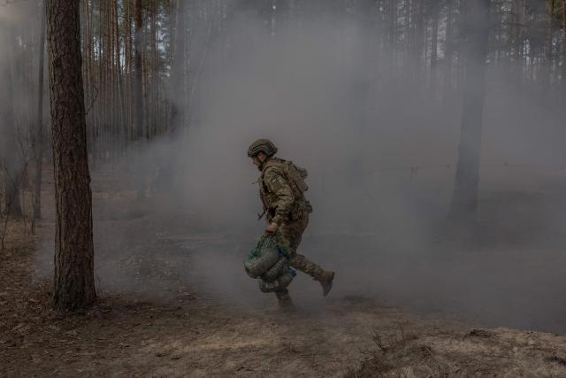 A Ukrainian recruit runs as he completes a basic military training at the Ukrainian Ground Forces training center in an undisclosed location on March 25, 2026, amid the Russian invasion of Ukraine. (Photo by Roman PILIPEY / AFP)