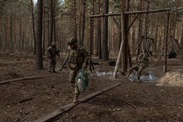 Ukrainian recruits complete a basic military training at the Ukrainian Ground Forces training center in an undisclosed location on March 25, 2026, amid the Russian invasion of Ukraine. (Photo by Roman PILIPEY / AFP)