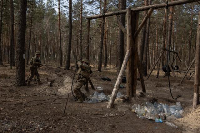Ukrainian recruits complete a basic military training at the Ukrainian Ground Forces training center in an undisclosed location on March 25, 2026, amid the Russian invasion of Ukraine. (Photo by Roman PILIPEY / AFP)