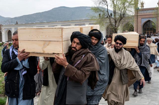 Afghan volunteers carry the coffins of victims killed by a Pakistani airstrike that struck a drug rehabilitation center, during the second mass funeral prayer ceremony at the Eid Gah Mosque in Kabul on March 26, 2026. A second mass funeral for about 60 victims of a Pakistani strike on a drug rehabilitation centre in Kabul was held on March 26, amid emotional scenes in the Afghan capital. (Photo by Wakil KOHSAR / AFP)
