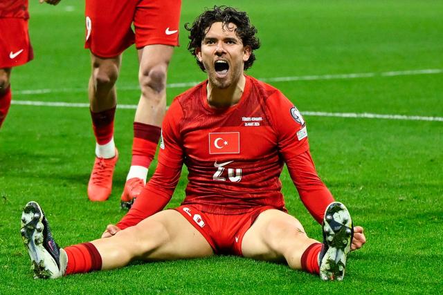 Turkey's defender #20 Ferdi Kadioglu (down) celebrates after scoring his team first goal during the play-off FIFA World Cup 2026 European qualification knockout semi-final football match between Turkey and Romania at Besiktas Park stadium, in Istanbul on March 26, 2026. (Photo by YASIN AKGUL / AFP)