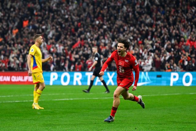 Turkey's defender #20 Ferdi Kadioglu (R) celebrates after scoring his team first goal during the play-off FIFA World Cup 2026 European qualification knockout semi-final football match between Turkey and Romania at Besiktas Park stadium, in Istanbul on March 26, 2026. (Photo by YASIN AKGUL / AFP)