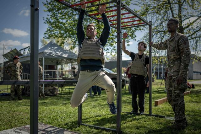 A young participant works through a monkey bars obstacle course during the Orion Jeunesse day at the Arts et Métiers campus in Talence, near Bordeaux, south-western France, on March 26, 2026. The Orion Jeunesse day, held as part of France's Orion 26 national military exercise, invited young people aged 15 to 25 to discover defence and resilience activities. (Photo by Philippe LOPEZ / AFP)