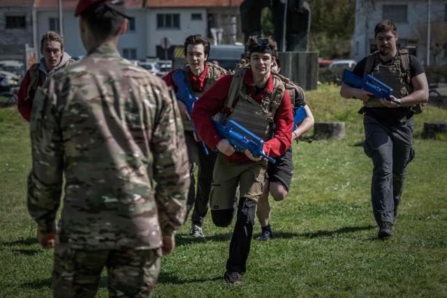 Young participants run carrying training rifles during a tactical exercise at the Arts et Métiers campus in Talence, near Bordeaux, south-western France, on March 26, 2026. The Orion Jeunesse day, held as part of France's Orion 26 national military exercise, invited young people aged 15 to 25 to discover defence and resilience activities. (Photo by Philippe LOPEZ / AFP)