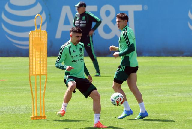 Mexico's defender Johan Vasquez (L) controls the ball next to defender Israel Reyes during a training session with head coach Javier Aguirre (back) ahead of their friendly match against the Portuguese national team in Mexico City on March 26, 2026. (Photo by Luis CORTES / AFP)