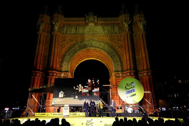 Mayor of Barcelona Jaume Collboni (L) and Tour de France General Director Christian Prudhomme (2L) take part the 100-Day Grand Depart Tour de France 2026 celebration, on March 26, 2026, while the Arch of Triumph is lit up in yellow in Barcelona. Barcelona today kicks off the 100-day countdown to the Tour de France 2026 which will start in this town on July 4, 2026. (Photo by Lluis GENE / AFP)