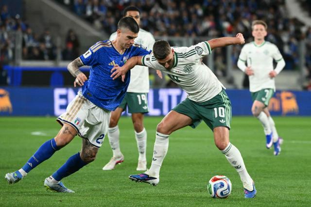 Northern Ireland's striker  #10 Jamie Donley fights for the ball with Italy's defender #23 Gianluca Mancini during the play-off FIFA World Cup 2026 European qualification semi-final football match between Italy and North Ireland at the Gewiss stadium in Bergamo, on March 26, 2026. (Photo by Alberto PIZZOLI / AFP)