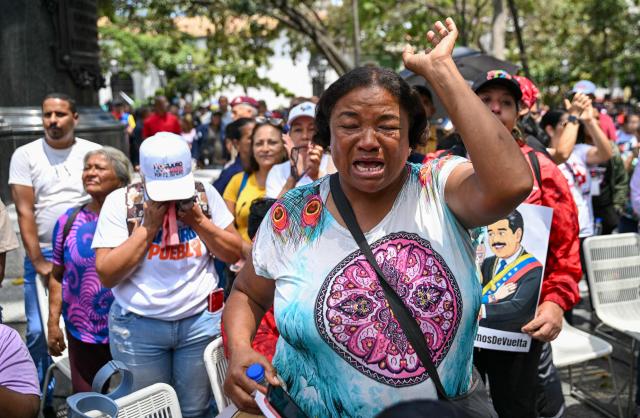 A supporter of Venezuela's ousted president Nicolas Maduro gestures during a demonstration in Caracas on March 26, 2026, as he appeared in court in New York. Ousted Venezuelan president Nicolas Maduro was back in a New York court on March 26, 2026 for his second appearance since his capture by US forces in an extraordinary nighttime raid. (Photo by Juan BARRETO / AFP)